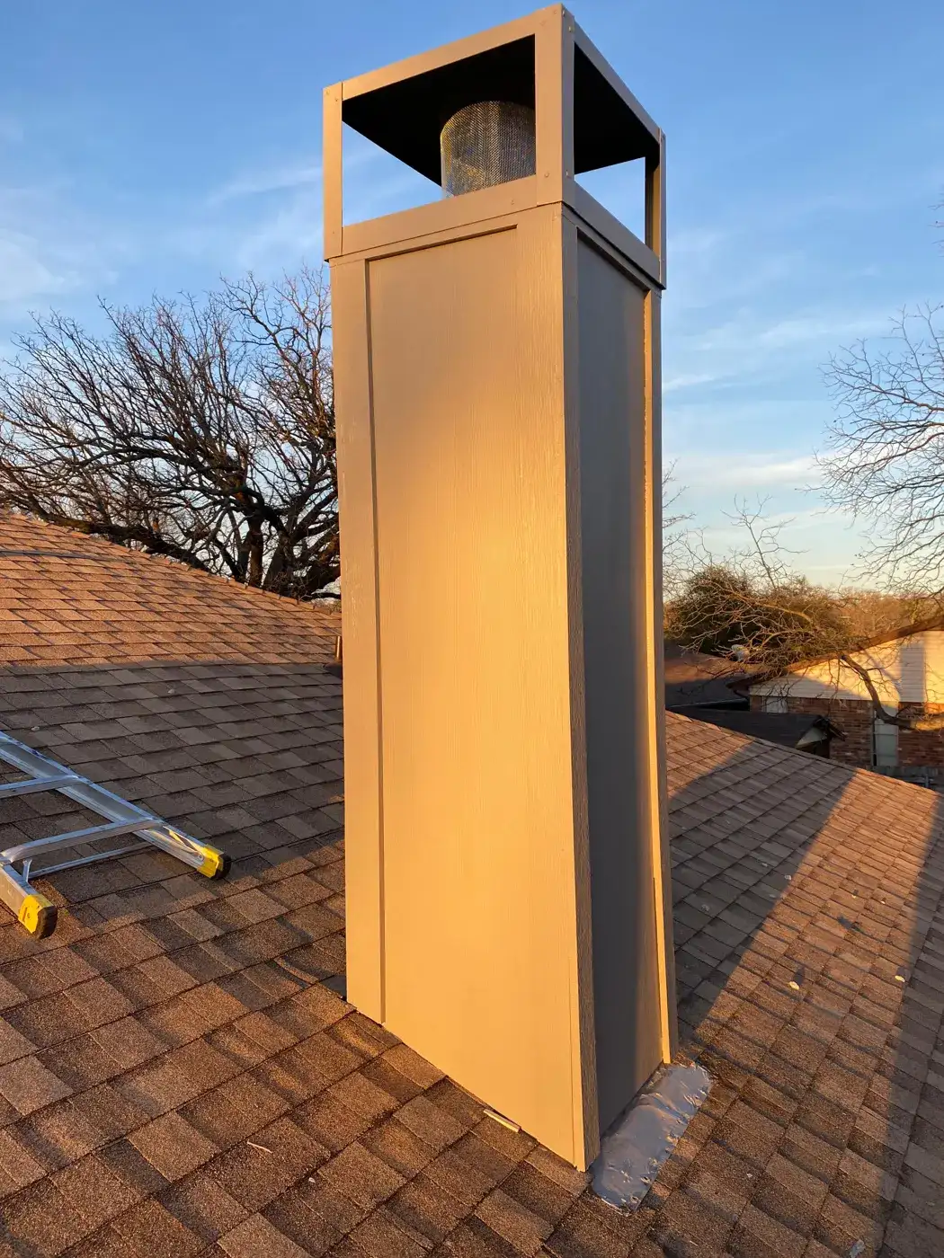 Finished chimney chase with new siding and a decorative shroud