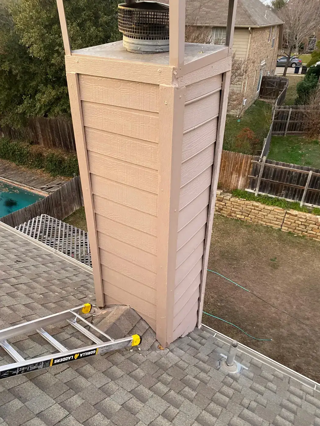Chimney chase with siding and a new chimney cap
