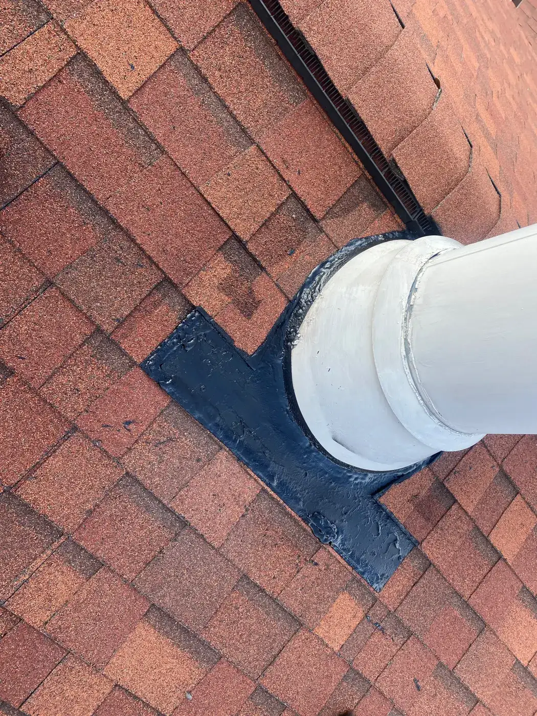 Sealed flashing around a vent pipe on a shingle roof
